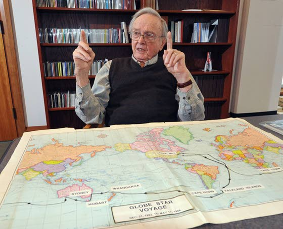 Dr. Creamer sitting at a table with a world map for an interview