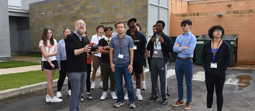 group of students watching a drone being flown at AES